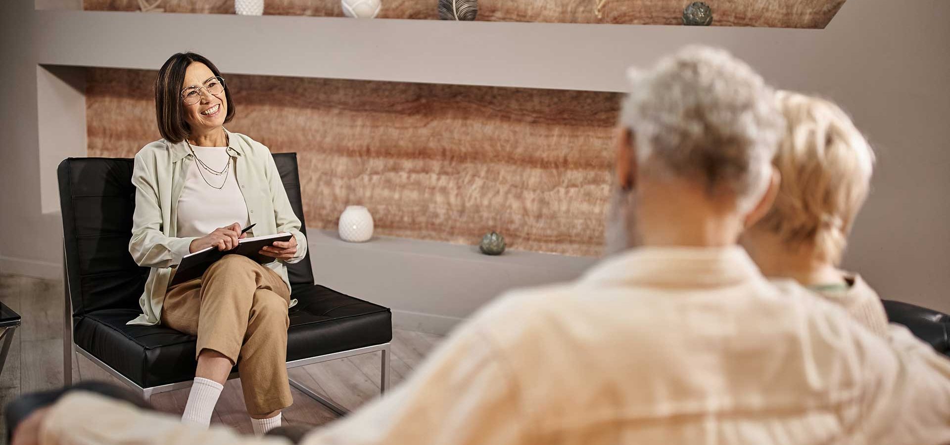 middle-aged-psychologist-in-glasses-sitting-near-m-2NNUKUS.jpg